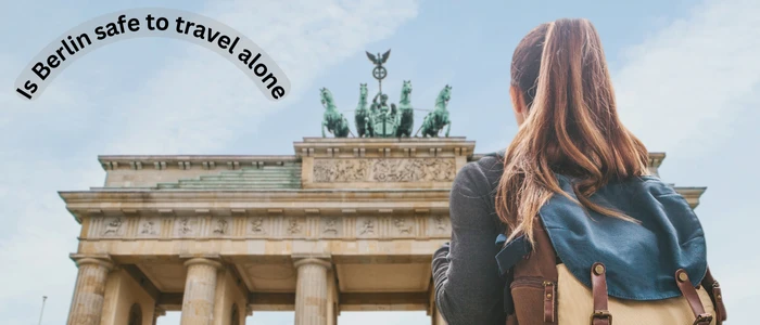 A woman poses in front of a building featuring "5 things to do in Berlin," reflecting on the safety of solo travel in the city.