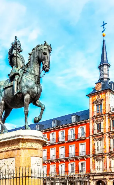 A statue of a man on horseback stands proudly in front of a historic building in Madrid, symbolizing the city's rich heritage.